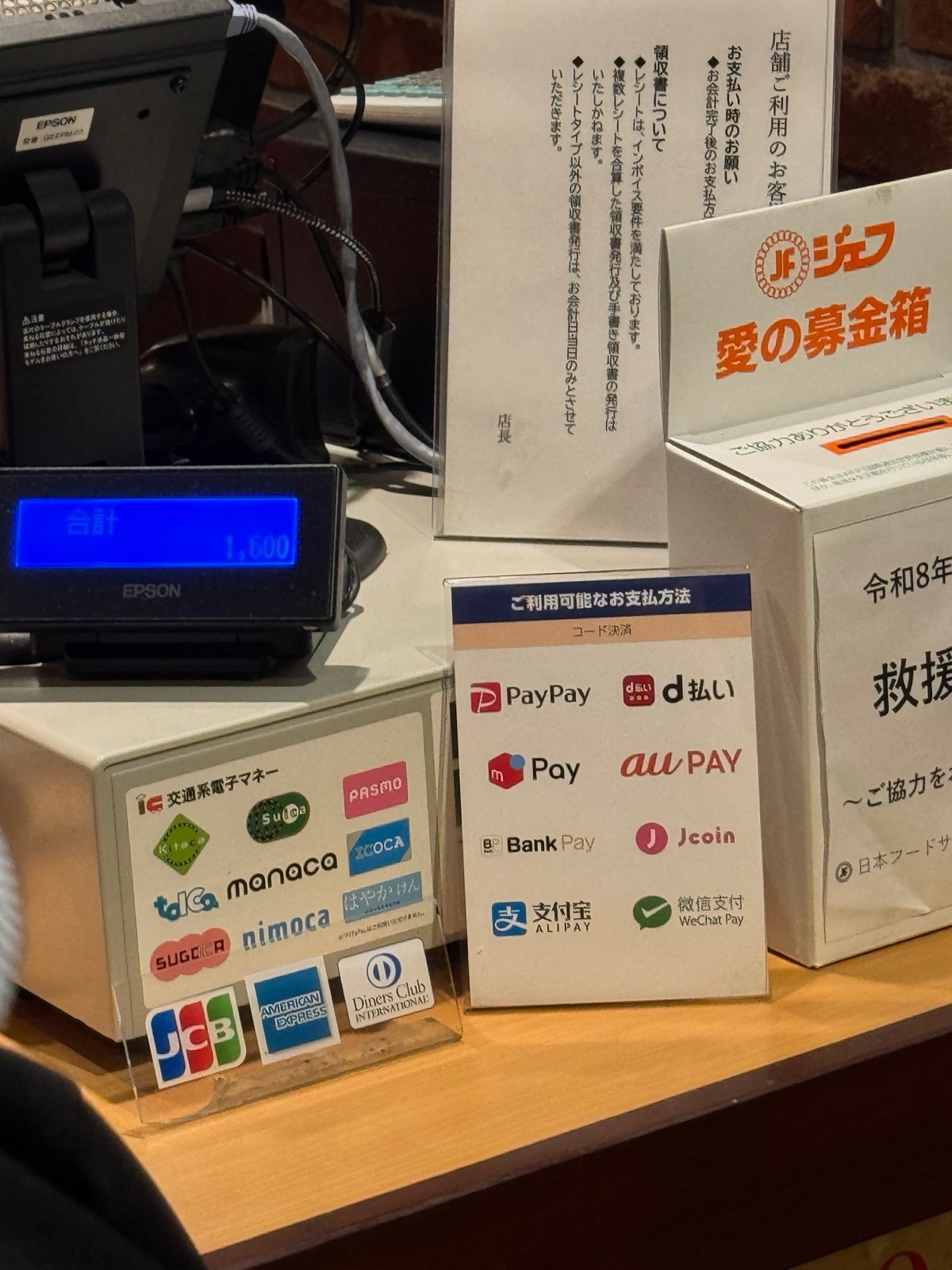 The payment sticker beside the register: IC cards, JCB/AMEX/Diners, and QR codes